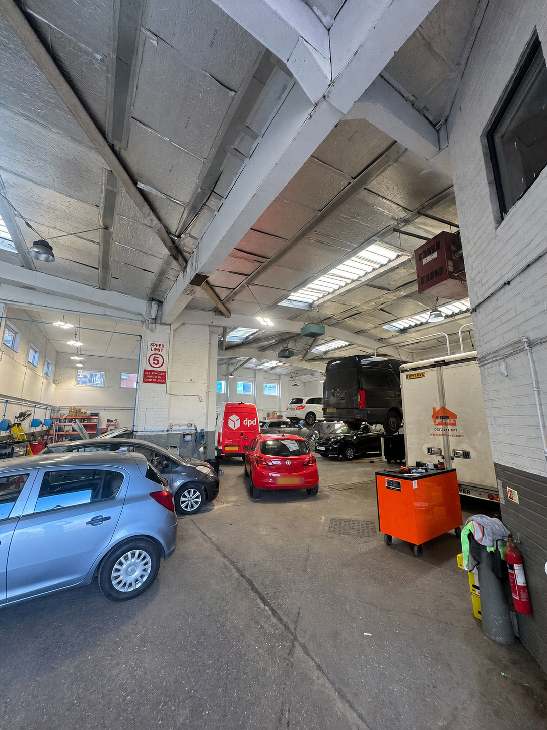 Wide view inside The Clutch Centre garage with cars and vans on lifts