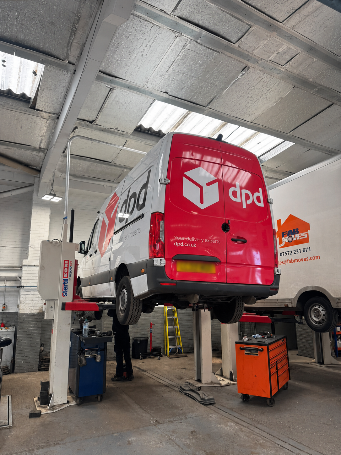 Delivery van raised on a garage lift