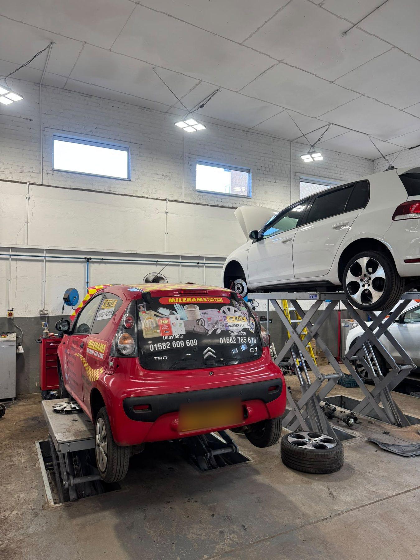 Two cars positioned on garage lifts