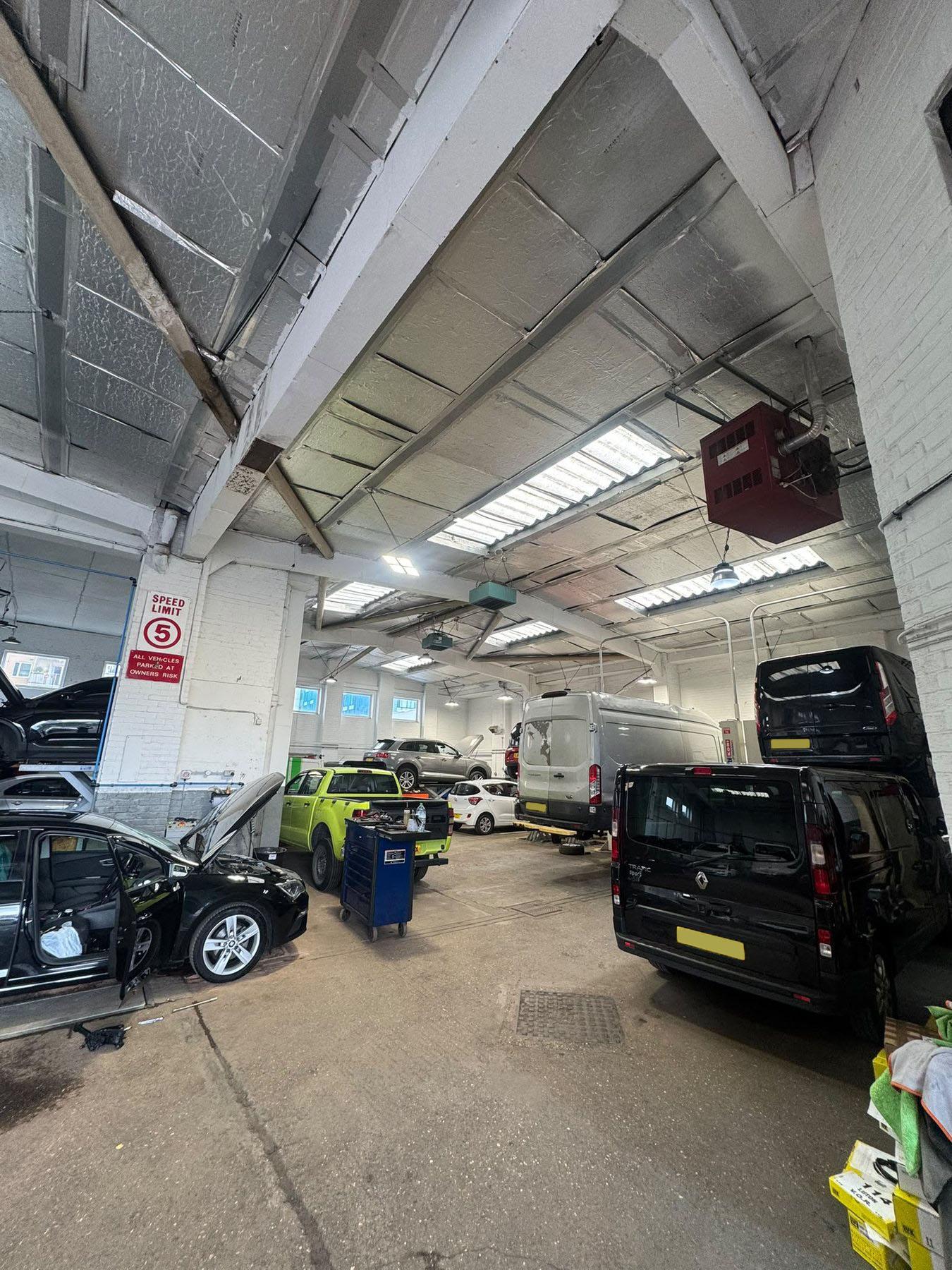 Wide view across the active garage floor and vehicle lifts