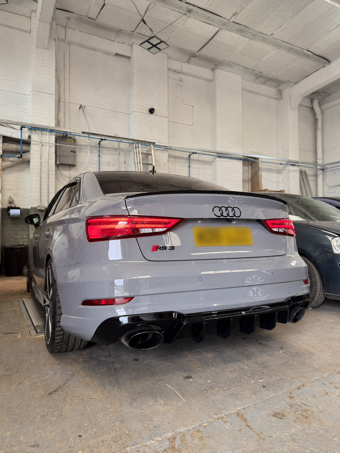 Grey saloon car raised in the garage