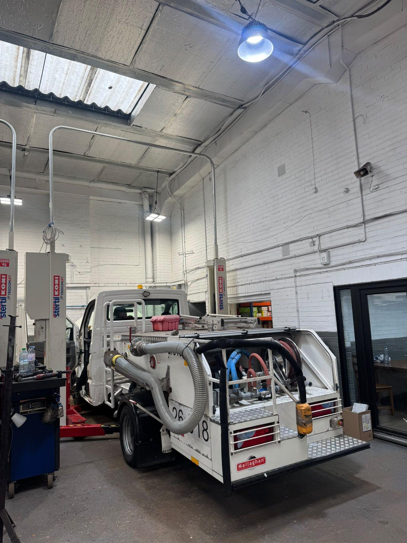 Garage service bay with a light commercial vehicle raised
